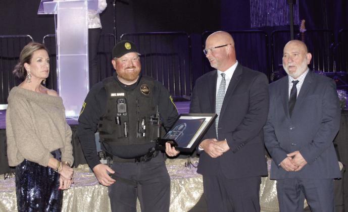 Sergeant Dennis Rains accepts the 2024 Ob cer of the Year Award from 2023 Ob cer of the Year Lt. Jason Crouch, third from left, during the 20th Annual "Celebration of Heroes" Shawnee Police Foundation Awards Banquet. File photo