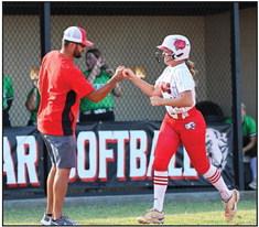 North Rock Creek Coach Griffin gives a fist bump congratulations to Molly Campbell as she rounds third base on her home run hit.