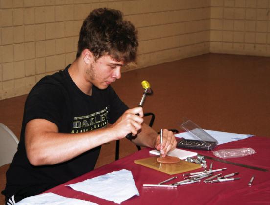 Trenton Thomas creates his own leather patch at the Tecumseh Public Library’s Summer Reading Program on Wednesday, June 7.