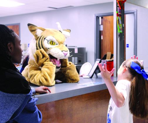 Knightly Houston, 8, tries to have a conversation using gestures with the Wildcat mascot at the concession stand, as Ellie Fulton, 11, watches, during the Bethel boys basketball home game on Dec. 5. Natasha Dunagan, Countywide &amp;amp; Sun