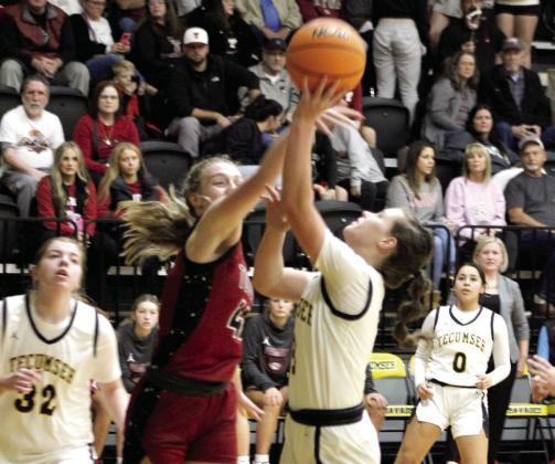 Tecumseh junior Katie Overstreet tries for a basket around a Tuttle defender.