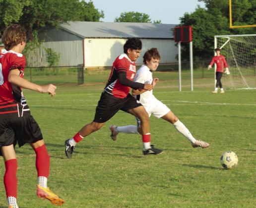 McLoud's Eduardo Manriquez jockeys for the ball, as teammate Liam Hutchins looks on, during the April 16 home soccer match with Crossings Christian.