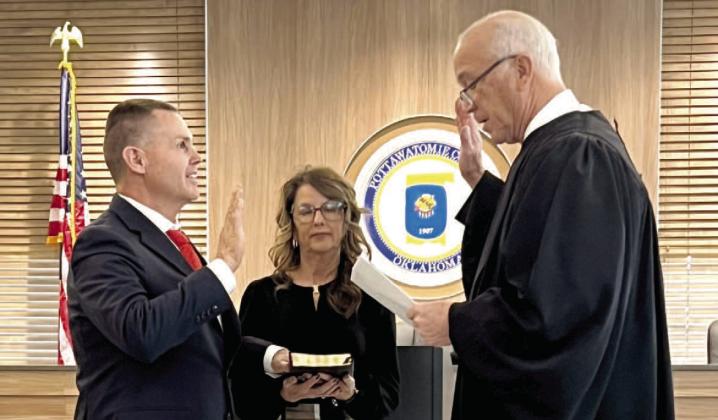 Pictured above, Oklahoma Supreme Court Justice Douglas L. Combs (right) swears in newly elected Sheria Freeland Wood (left). Holding the bible is Wood's wife, Shirley. Pictured below, ottawatomie County Clerk Raeshelle Flewallen swears Macomb Trustee 1 David Grib th and Trustee 2 Tami Perez into ob ce. Perez won the coin toss for the position of Mayor File photos