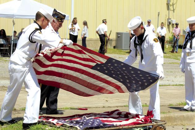 American Legion Post #260 Commander Tom Snodgrass supervises as U.S. Naval Sea Cadets Aaron Shattuck and Joeby Komppa place flags on a grate to be retired by fire during the Flag Day Celebration and Flag Retirement in Tecumseh, June 15. Countywide &amp; Sun/Natasha Dunagan