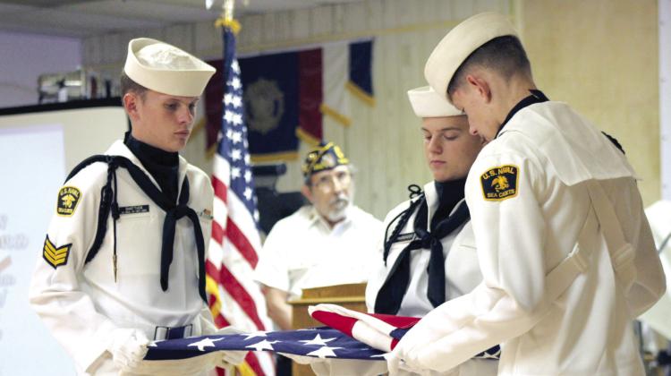 The U.S. Naval Sea Cadets Color Guard - which includes Seaman Aaron Shattuck, Seaman Recruit Zane Finkenbinder, and Seaman Apprentice Joeby Komppa - perform a flag-folding ceremony during the Flag Day Celebration and Flag Retirement at American Legion Post #260 in Tecumseh, June 15. American Legion Auxiliary Member Julia Watters read the meaning behind the 13 folds. Countywide &amp; Sun/Natasha Dunagan