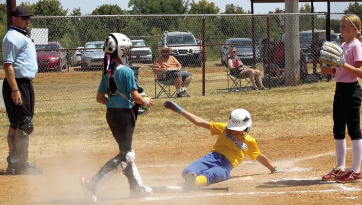 A 'Defenders' player from Holdenville slides into home, as members of the 'Synergy' team from Ada and Umpire Jay Scoggins look on. Scoggins began the Oklahoma Dust team and is a family friend of Tyler and Samantha Gensman, who along with their whole family, have managed the complex for about 10 months.