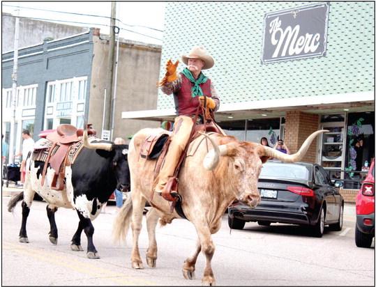 Roger Straka waves from his Longhorn bull, followed by another, in the McLoud Blackberry Festival parade on July 8. Countywide &amp;amp; Sun/Natasha Dunagan