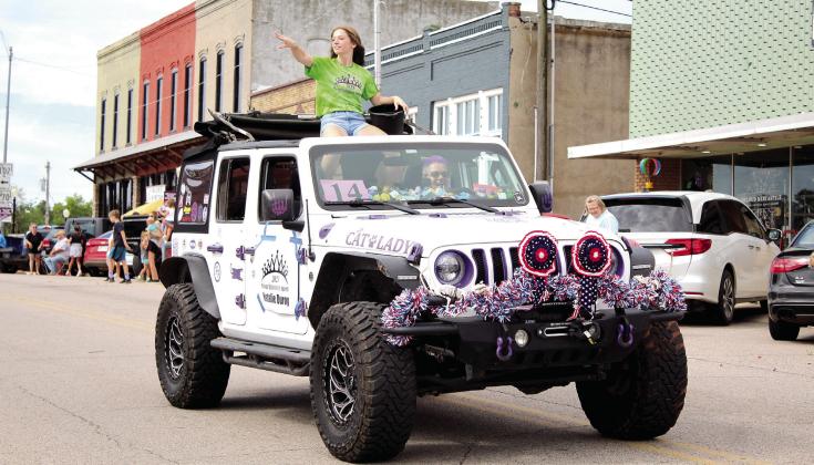 The 2023 McLoud Blackberry Queen Natalie Duroy throws candy from atop a Jeep in the McLoud Blackberry Festival parade.