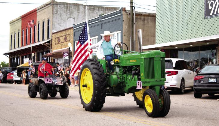 Jim Craig drives his 1954 John Deere Model 60, which he named Ms. Daisy, in the parade. Behind Craig is Jimmy Higdon of Higdon Farms.