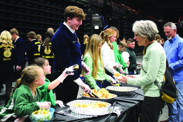 Tecumseh 4-H members Jessi Peacock and Adalyn Seaton and North Rock Creek FFA member Gus Goodson serve Delinda Curtis rolls and butter during the 34th Annual Pottawatomie County Junior Livestock Show Pig Roast and Trophy Auction on Feb. 6, 2023. Natasha Dunagan, Countywide &amp;amp; Sun