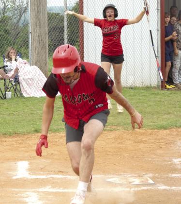 Macomb senior Radlee Blaine completes a home run, as sophomore RyLee Hancock cheers him on.