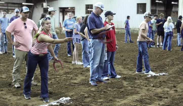 Taylor Marlow of Bethel and Paul Griggs of Shawnee compete in the horseshoe toss during the 16th Farmhand Olympics, presented by the Pottawatomie County Farm Bureau at the Free Fair on Sept. 3. Oklahoma Farm Bureau member Burton Harmon, taking notes on the horseshoe contest, held a demonstration using impairment goggles and spoke about the dangers of driving impaired. This year, agriculture students from Bethel, McLoud, North Rock Creek, Dale, Shawnee and Macomb participated, and they also had a dance.