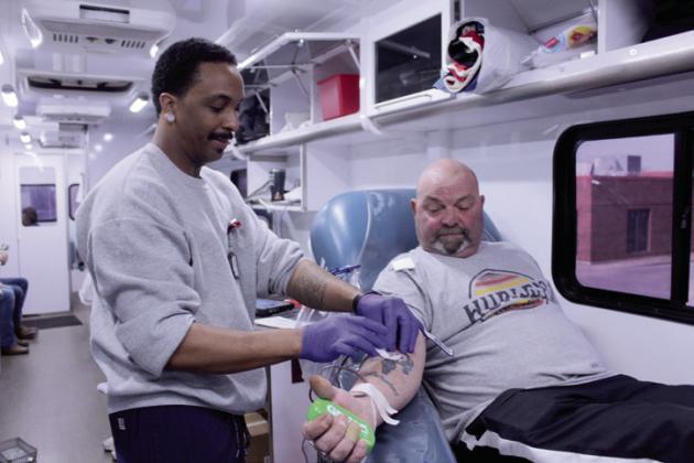 Thomas Smith, with Jordan Contractors, looks on as Oklahoma Blood Institute Phlebotomist Trey Brown tapes down the needle during Smith's blood donation. Smith said he began giving blood while working 30 years ago when they offered him the rest of the day off, and he said it made him feel better. Now, he donates every three months because it helps him and someone else. Natasha Dunagan, Countywide &amp; Sun