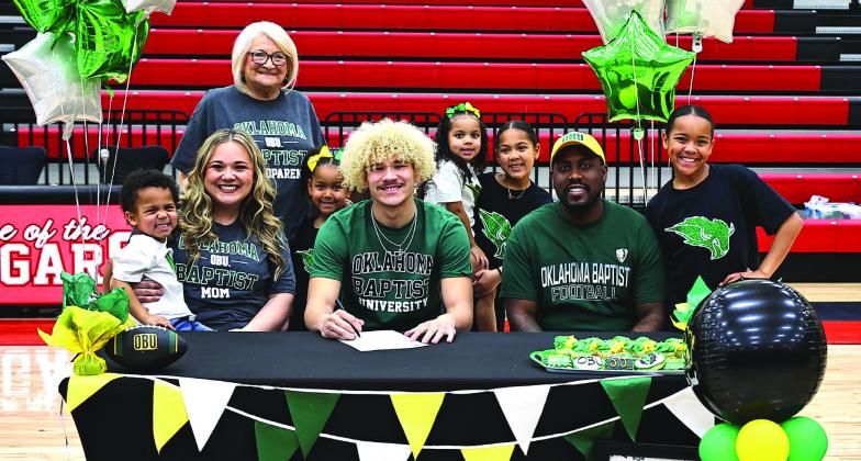 North Rock Creek's JJ McClain signs letter of intent with Oklahoma Baptist University to play football. JJ is surrounded by his family, Rachel Spencer, Kadeem Gaines, his Nana Cyndi Hanft, and his brother and sisters, Miami, Kadence, Kami, Jayson, and Willow.