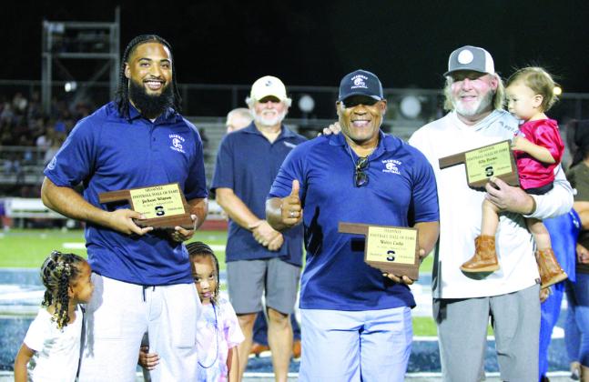 Jackson Winrow, Walter Cudjo and Coach Billy Brown were inducted into the Shawnee Football Hall of Fame during halftime of Shawnee’s first home game on Sept. 13. Winrow, Class of 2016, is joined by his twin daughters, Alani and Jaielle, 4. The late Walter Cudjo’s son, Anthony Derone Cudjo, accepted his plaque. The elder Cudjo was in the Class of 1959. Brown, holding his grandson Archie Kin, 17 months, was a football coach at Shawnee from 2004 to 2019. Countywide &amp; Sun/Natasha Dunagan