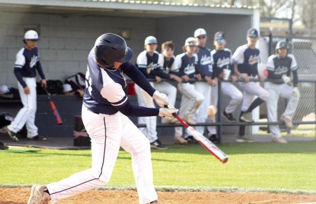Asher junior Brogan Culwell hits a double, as his team in the dugout looks on.