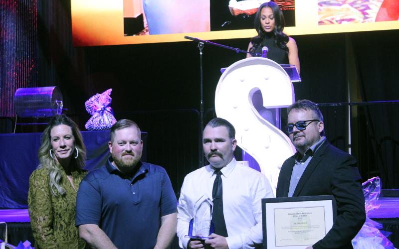 Corporal Josh Soward, third from left, accepts the 2025 Officer of the Year Award Jan. 30 presented by Shawnee Police Foundation Chairman Melissa Stuteville, 2024 Officer of the Year Dennis Rains, and Shawnee Police Chief Mason Wilson. KOCO Channel 5 News Anchor Kylie Walker, on stage, was the emcee for the evening. Natasha Dunagan, Countywide &amp; Sun