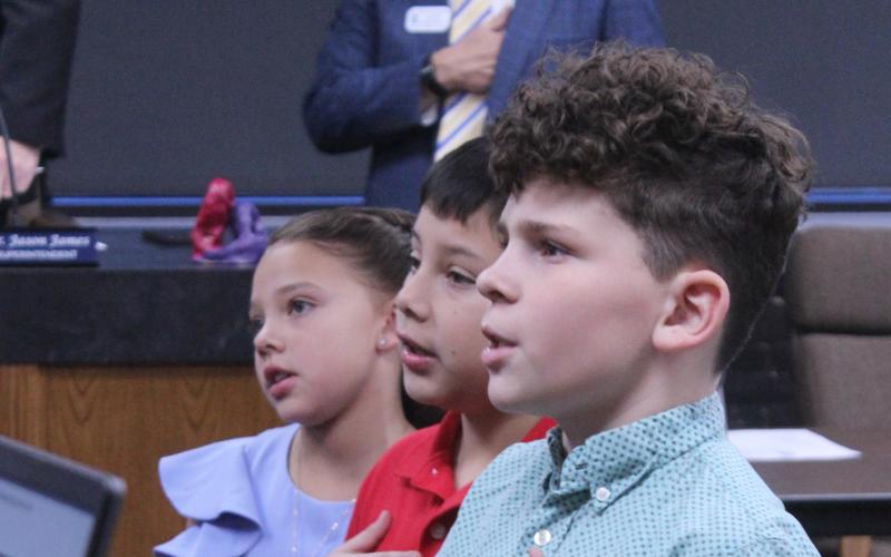 Shawnee students Charlyne Jones, Cordan Jones and Jaxon Wano lead the flag salute to the United States flag during the Feb. 9 Shawnee Board of Education meeting. Natasha Dunagan, Countywide &amp; Sun