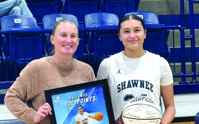 Coach Wendi Wells presents Shawnee senior Daley Rice with a framed photo and a game ball in recognition of Rice reaching 1,000 high school career points in January. Photo provided by Shawnee Public Schools