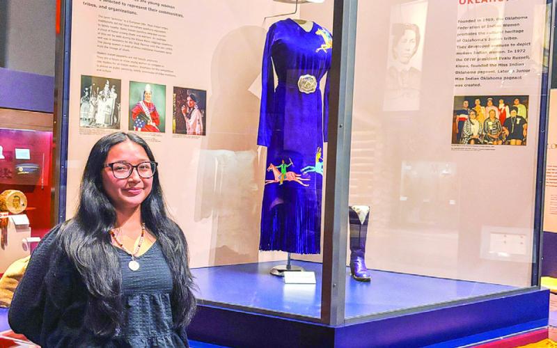 Seminole State College freshman Alivia Wapskineh, 2025 Miss Seminole Nation, stands in front of the Indian Princesses exhibit at the Oklahoma History Center. Photo Provided
