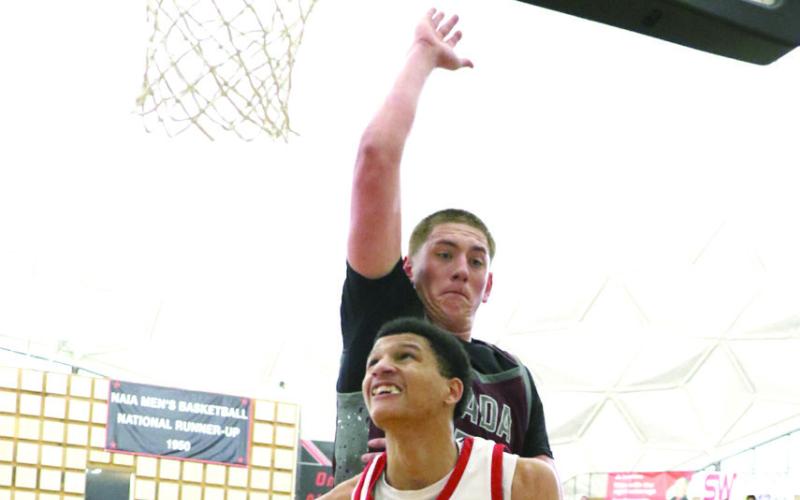 Photos Courtesy of Kent Bush Left: McLoud's Edan Litherland tosses in two in the 4A Area II game against Ardmore hosted by East Central University on Mar. 5. McLoud won by a narrow margin, 62-61, before falling to Ada the next night, 48-58. Right: Ladamien Williams makes a basket.
