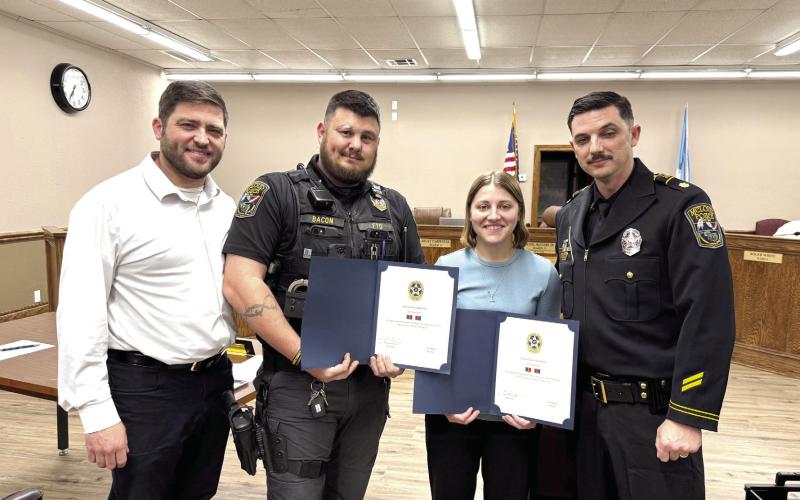 McLoud Mayor Daniel McClure (left) and Major Alan Pinette (right) pose with Sgt. Chris Bacon and Officer Taylor Swanson. Bacon and Swanson were both given commendations for providing life saving treatment to citizens last month, on separate occasions. Julie Talton, Countywide &amp;amp; Sun