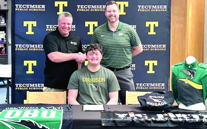 Tecumseh's David Lawrence signed with Oklahoma Baptist University Bison Brigade Band. Shown shaking hands are Tecumseh Band Director John Outon, left, and OBU Band Director Dr. Brian Stackhouse. Photo provided by THS