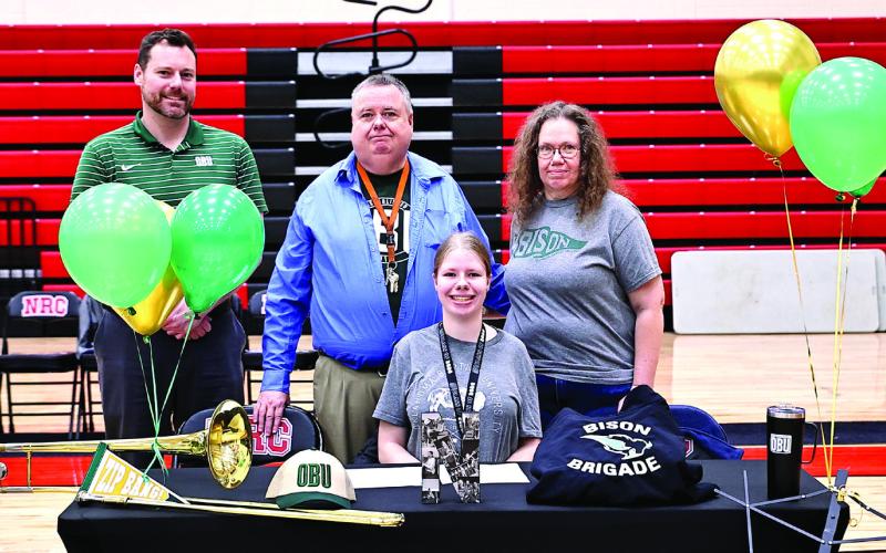 Noami Daubert signs with OBU band, with her parents, Lynne and Tom Daubert, and Dr. Brian Stackhouse, OBU Athletic Band. Photo Courtesy of Gowin Photography