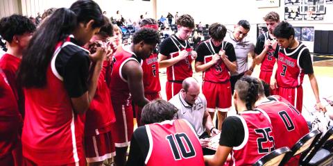 The Earlsboro Wildcats huddle around Coach Chad Rochelle during a tight game in Roff.