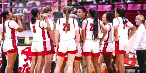 The Lady Wildcats listen to Coach Tim Gentry during a timeout in Earlsboro.