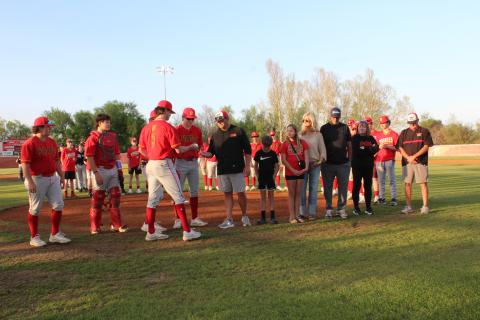 Dale senior Cade Dickinson and his fellow seniors present a commemorative game ball and Dale Pirates hat to 2001 graduate Eric Thornton during a special presentation on April 8 before the varsity baseball game.