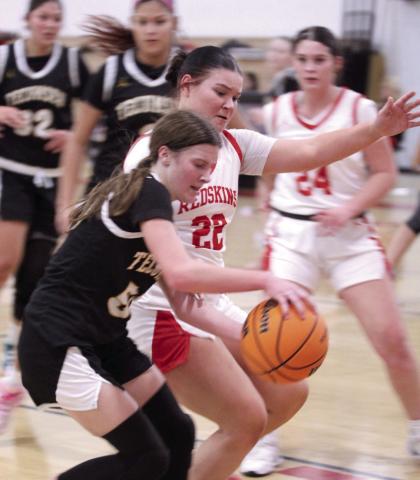 Tecumseh sophomore Sosi Mitchell brings the ball to her teammates, as McLoud's Anna Sharp tries to steal, during the Class 4A District Tournament home game on Feb. 21. The Lady Redskins won 79-30, and advanced to the Regional Tournament at home on Feb. 24. The Lady Savages play Ada in the Regional Consolation Bracket today (Feb. 26) in McLoud at 6 pm.
