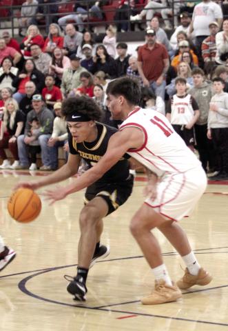 Tecumseh senior Jekhi Owens guards the ball, as McLoud's Phoenix Lopez tries to steal, during the Class 4A District Tournament home game against Tecumseh on Feb. 21. y
