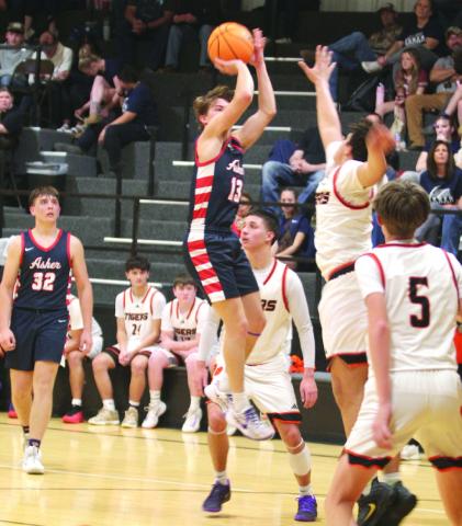 Asher senior Pierce Aduddell launches a trey, as Maud freshman Jonathan Lamas plays defense, during the Class B2 Regional Tournament, held at Maud on Feb. 17. The Indians won this game, 66-35, as well as the second round against Mill Creek, and advance to the Area Tournament. The Tigers won against New Lima and Bowlegs in the Consolation Round and also advance to Area at the Mvskoke Dome today (Feb. 26). Photos by Natasha Dunagan, Countywide &amp;amp; Sun