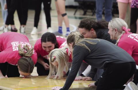 The Bethel Lady Wildcat senior basketball players kiss a section of their home court, which was brought to the Noble Complex at OBU, in Shawnee, on Feb. 13. Since 1999, it is tradition for Bethel High School seniors to kiss the court or home plate before they graduate. Assistant Athletic Director Jennifer Lynch announced that the section of basketball court was provided after the seniors and coaches have been through the pandemic, and their home gym has seen flooding, missed games, and a splintered floor.