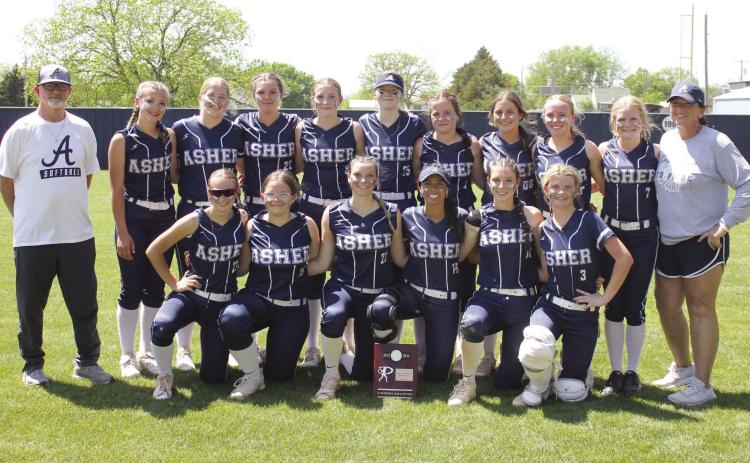 The Asher Lady Indians pose with Head Coach Tari Dubler, far right, and Assistant Coach Scott Dubler, far left, as well as their Class B District Slow Pitch Champion trophy on April 17. They beat Paden in a double header, 12-0 and 26-0, to take districts. On April 24, they played in regionals at Caney and lost, 6-10, but they won with Pittsburg, 9-5. Photo provided.