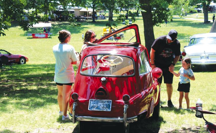 Abby Thompson, 12; Sarah Thompson; Ken Thompson; and Cora Thompson, 4, all of Tecumseh, look over a 1958 BMW Isetta 300, owned by Philip Farmer for the last 25 years. The Isetta won “Most Unusual” in the 36th Annual Knights Auto Club Car Show, held at Boy Scout Park on June 24. The event attracted more than 200 vehicles. Countywide &amp; Sun/Natasha Dunagan