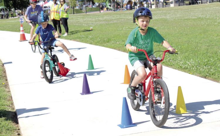 Dillon Beck, 7, of Shawnee, leads two other bicyclists during the Bike Safety Blitz at the Fun Day at Kidspace Park in Shawnee on May 30. Fun Day was part of Health Week, which is sponsored by the Avedis Foundation, and offered a variety of activities in the morning and evening. Pottawatomie Go (POGO) sponsored the bike safety event and several other events. Natasha Dunagan, Countywide &amp; Sun