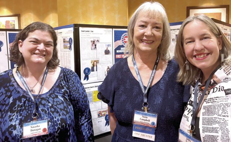 The Countywide & Sun's Natasha Dunagan, Suzie Campbell, and Julie Talton pose in front of the first place In-Depth Reporting page. The team brought home multiple awards in its division at the Oklahoma Press Association's annual Better Newspaper Contest.