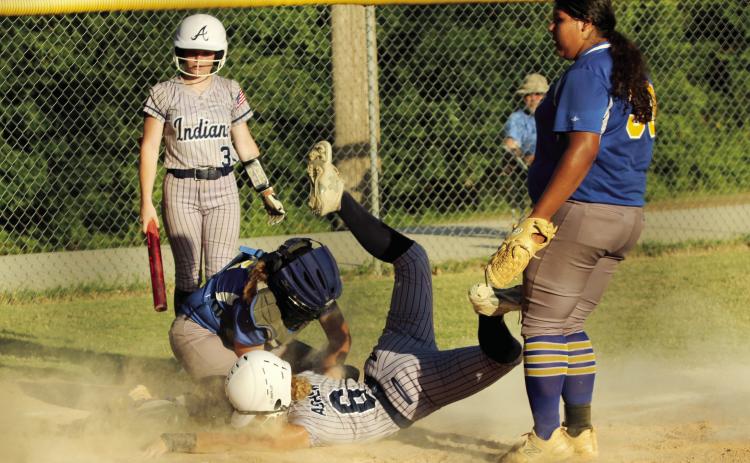 Asher junior Gracie Swinney dives into home only to be tagged out by the Moss catcher, as fellow junior Makaylee Harrell waits to finish batting, during the home game on Aug. 15. The Lady Indians played their first five fast pitch games of the season at home last week and won all but one. They beat Moss, 11-6.