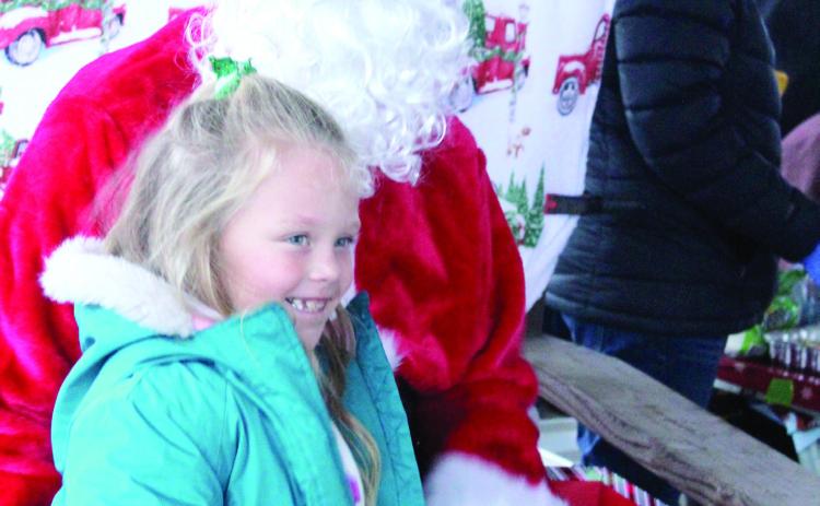 Hallie Belle Harris, 6, gets a candy cane from Santa during the Bethel Community Christmas Tree Lighting Ceremony on Dec. 7 at the Community Center Pavilion.