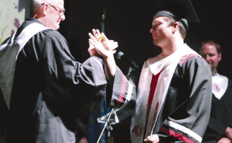North Rock Creek High School Principal Chad Brooking shares a secret handshake with his son Holden Brooking after the graduate received his diploma at graduation on May 19. Countywide &amp; Sun/ Natasha Dunagan
