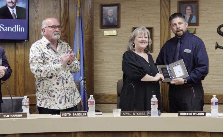 Shawnee Superintendent Dr. Aaron Espolt presents a clock plaque to retiring Board of Education Clerk April Stobbe, as fellow retiring board member Keith Sandlin and others applaud during the April 1 board meeting. This was the last meeting for Stobbe and Sandlin after more than 20 years each. Countywide & Sun/Natasha Dunagan
