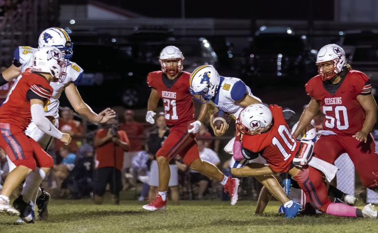 Bethel sophomore Bryce Tapley runs the ball as McLoud senior Ben Greenberg tries to take him down during the game at McLoud on Sept. 9. McLoud won 21-7. Photo provided by Richelle Treece.