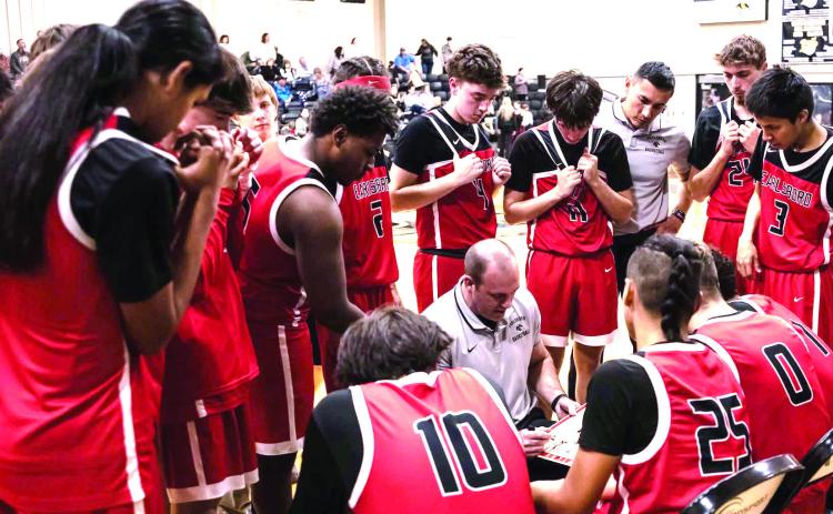 The Earlsboro Wildcats huddle around Coach Chad Rochelle during a tight game in Roff.