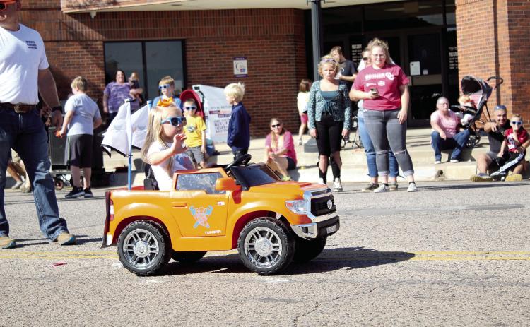 A little girl, with Cowboys Plumbing, waves from her battery-operated truck during the Frontier Days Parade on Sept. 25, 2021. Cowboys Plumbing also had a horse and buggy and a cowboy mascot in the parade. Countywide &amp; Sun/Natasha Dunagan