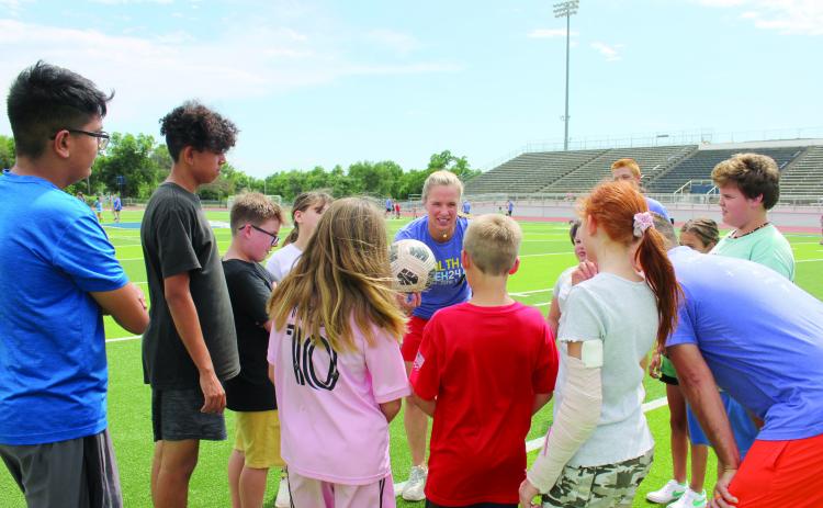 Lindsay Tarpley reminds one group of kids what they need to work on during her soccer demonstration, sponsored by POGO for Health Week, at Jim Thorpe Stadium, May 28. About 50 children, ages 6-15, participated in the event, and 20 volunteer coaches led groups in the instructional practice. Tarpley was on the U.S. Women's National Soccer Team when they won the Gold Medal in both 2004 and 2008. She now co-owns World Champion Soccer Academy with her husband and is a keynote speaker.
