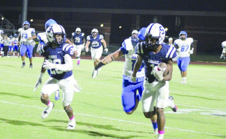 Shawnee junior Ejion Thomas carries the ball, as fellow junior Deetrick Beavers keeps an eye on the Southeast defense.