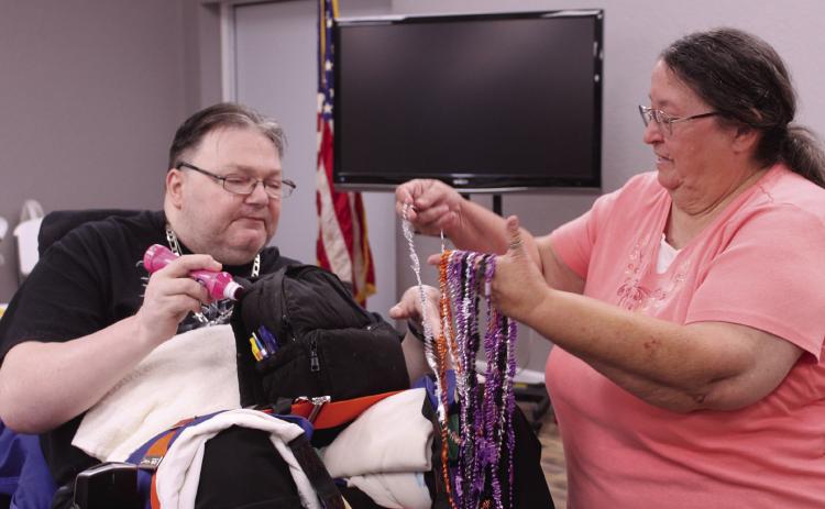 Shawnee American Legion Auxiliary Vice President Jamie McCraw offers a necklace to Billy Heavner during the monthly bingo for nursing home residents at American Legion Gill-Mattox Post 16 on Oct. 15. This is the third time the post has held the special bingo event, which is on the third Wednesday of each month now. Natasha Dunagan, Countywide &amp; Sun