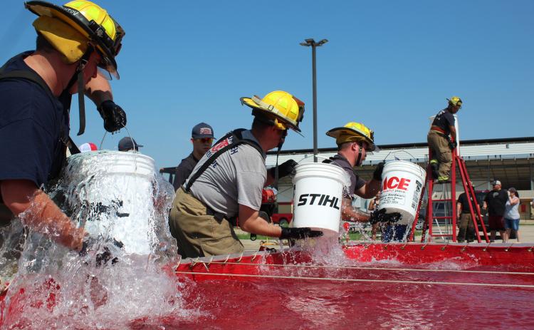 Tecumseh firefighters race the clock in the Bucket Brigade event of the Firefighter Olympics at the Pottawatomie County Free Fair on Sept. 10. Shown, from left, are Connor Franetovich, Zac Stephenson, Eddie Kidney, and on the ladder, Caden Shirey. Watching from the background is Preston Hurst. The event is organized by rural fire coordinator and retired Shawnee firefighter Paul Simpson, and has been since 1996. Countywide & Sun/Natasha Dunagan